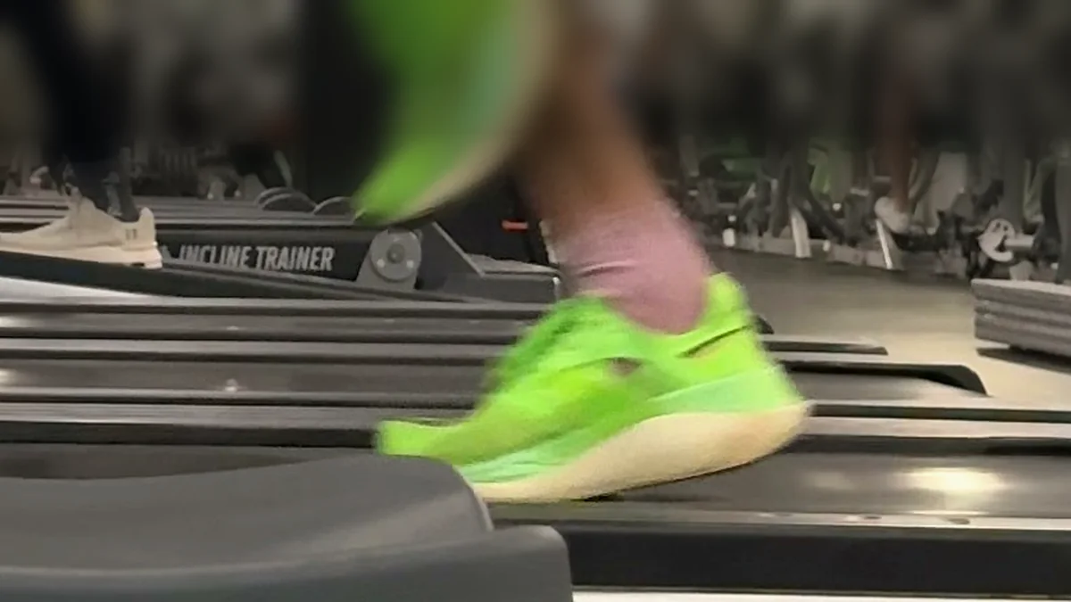 Close-up of a runner's shoe touching down on a treadmill belt